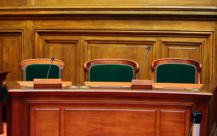 Empty vintage court’s room with table,chairs and microphones.